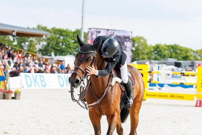 Reiterin lobt ihr Pferd nach dem Parcours
